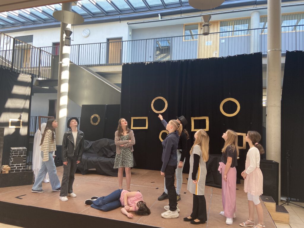 Schüler auf einer Bühne, Theater spielend.
